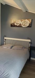 a bed in a bedroom with a painting on the wall at Chambre indépendante 1 lit 2 pers maison calme in Romans-sur-Isère