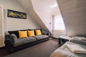 a living room with a couch and yellow pillows at Zajazd Fojutowo in Legbąd +31 photos