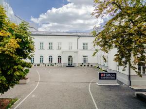 a white building with a sign in front of it at Hilton Garden Inn Radom in Radom