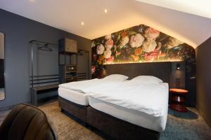 a bedroom with a large bed with a floral wall at Hotel Elsen in Grevenbroich