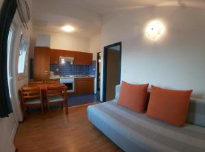 a living room with a couch and a kitchen with a table at Sanja Apartments Posedarje in Posedarje