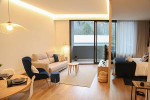 a living room with a bed a couch and a table at Apartamento Hortensia Diseño Exclusivo in Ponteareas