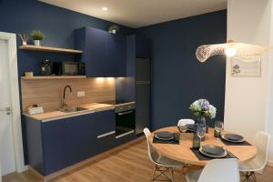 a kitchen with blue walls and a table with chairs at Apartamento Hortensia Diseño Exclusivo in Ponteareas