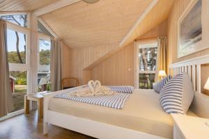 a bedroom with a large bed with striped pillows at Dünenblume - Baabe in Baabe