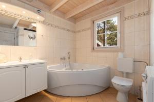 a white bathroom with a tub and a toilet at Dünenblume - Baabe in Baabe