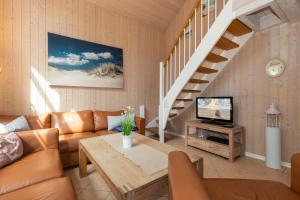 a living room with a couch and a tv at Dünenblume - Baabe in Baabe