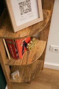 a wooden book shelf with books and a picture at Apartamento Diseño Myrtus in Ponteareas