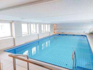 a large swimming pool with blue water in a building at Haus Nautic Wohnung 615 in Cuxhaven