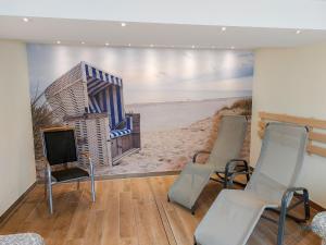 a room with three chairs and a tv and a mural at Haus Nautic Wohnung 615 in Cuxhaven