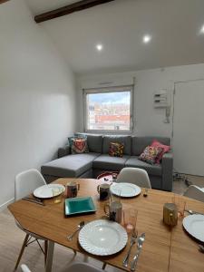 a living room with a table and a couch at Le cocon des Sacres in Reims