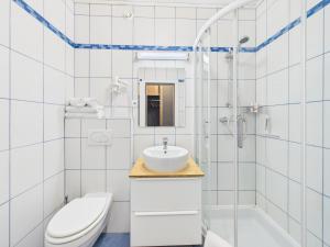 a white bathroom with a sink and a toilet at Boutique73 Sunset in Altossiach