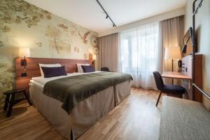 a hotel room with a large bed and a desk at Scandic Södertälje in Södertälje +26 photos