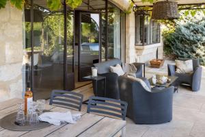 a patio with a table and chairs and a glass door at Mas De Rosemarie in Joucas