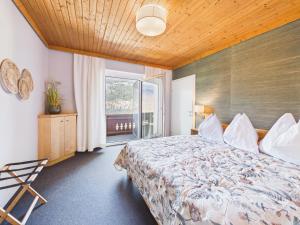 a bedroom with a bed and a large window at Boutique73 Sunset in Altossiach