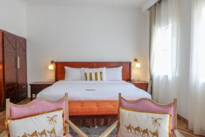 a bedroom with a large bed and two chairs at Mount Elgon Hotel & Spa in Mbale +31 photos
