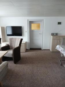 a living room with a television and a door at Haus Angermann in Struppen
