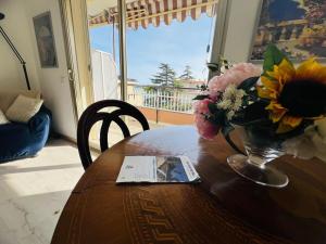 a wooden table with a vase of flowers on it at Suite Semeria 466 - Sanremo in Sanremo +8 photos