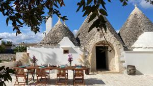 a house with a table and chairs in front of it at Trullo al borgo in Cisternino