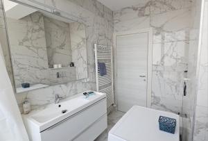 a white bathroom with a sink and a mirror at NORDIC Residence Apart Hotel in Suceava +138 photos