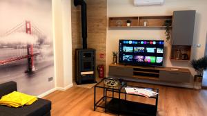 a living room with a tv with a bridge on the wall at Castello Rosso Apartman in Pilisvörösvár