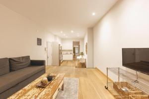 a living room with a couch and a flat screen tv at Bravissimo Força 17, Barri Vell apartments in Girona