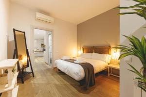 a bedroom with a large bed and a mirror at Bravissimo Força 17, Barri Vell apartments in Girona