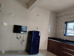 a kitchen with a refrigerator and a tv on the wall at Punawale tathwade 1bhk in Méribel Village