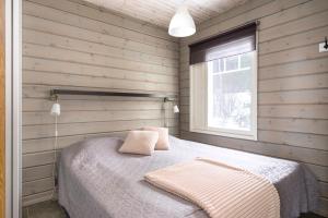 a bedroom with a bed in a wooden wall at Villa Peso 2 Incl WiFi, AC and Jacuzzi for extra fee in Himos
