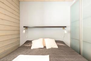 a bedroom with a bed with two white pillows at Villa Peso 2 Incl WiFi, AC and Jacuzzi for extra fee in Himos