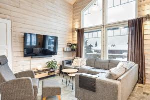 a living room with a couch and a tv at Villa Peso 2 Incl WiFi, AC and Jacuzzi for extra fee in Himos