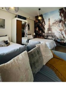 a bedroom with two beds and a mural of the eiffel tower at Deck&Dwell in Trece Martires