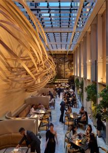 a restaurant with people sitting at tables in a building at Mandarin Oriental Mayfair, London in London