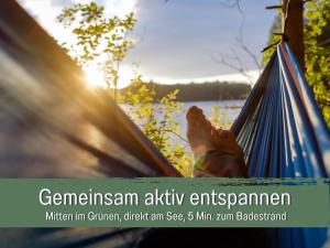a person laying in a hammock near a lake at 360 Grad by teamgeist Apartmenthaus - familienfreundlich - direkt am See mitten im Naturpark - Wassersportaktivitäten vor Ort in Kolberg +42 photos