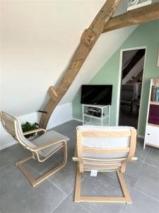 a living room with a chair and a television at The BEE Garden in Lede
