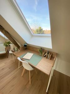 an attic room with a desk and a window at The BEE Garden in Lede