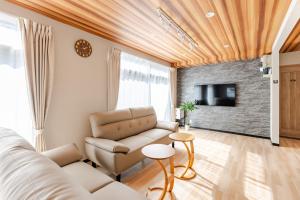 a living room with a couch and a tv at トキテラス五条 in Dazaifu