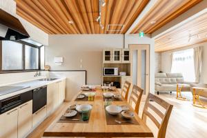 a kitchen and dining room with a wooden table at トキテラス五条 in Dazaifu