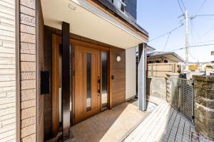 a house with wooden doors on the side of it at トキテラス五条 in Dazaifu