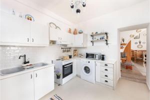 a kitchen with white cabinets and a sink and a dishwasher at Traditional Dream House in Soroni