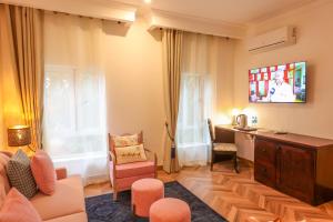 a living room with a couch and a tv at Mount Elgon Hotel & Spa in Mbale