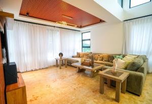 a living room with a couch and two tables at Modern Villa with a 15m Lap Pool, Cabarete in Cabarete