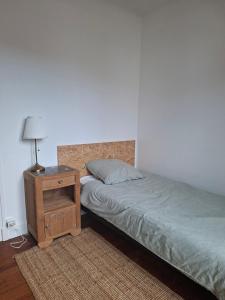 a bedroom with a bed and a night stand with a lamp at Gîte chez Maritxu in Saint-Étienne-de-Baïgorry +11 photos