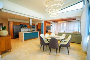 a kitchen and a dining room with a table and chairs at Modern Villa with a 15m Lap Pool, Cabarete in Cabarete