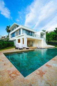 a house with a swimming pool in front of a house at Modern Villa with a 15m Lap Pool, Cabarete in Cabarete