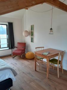 a living room with a table and a chair at Sport B&B De Veluwezoom in Velp