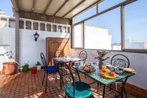 a patio with a table and chairs with food on it at Riad Jasmine in Rabat
