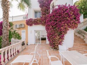 a house with flowers on the side of it at Villa in Cala Llonga near Beach & Ferry Port in Cala Llonga