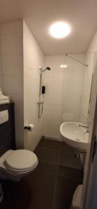ein weißes Badezimmer mit Toilette und Waschbecken in der Unterkunft Seehotel Oostkapelle in Oostkapelle + 73 Fotos