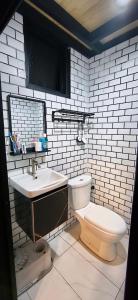 a white bathroom with a toilet and a sink at Sekinchan Tiny House - Moslim Only in Sekinchan +15 photos