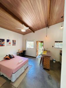 a bedroom with a bed and a wooden ceiling at Flor e Luz Chalés in Vale do Capao